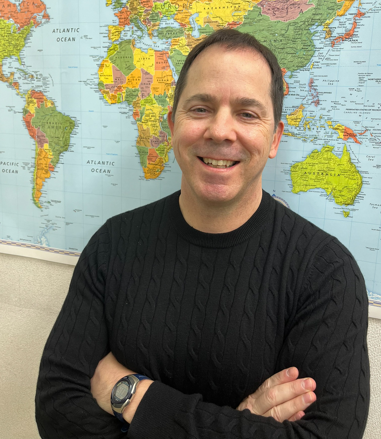 James Williams, founder and head teacher at BumbleB English, in front of a world map